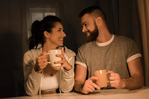 Молодые возлюбленные пьют кофе дома — стоковое фото