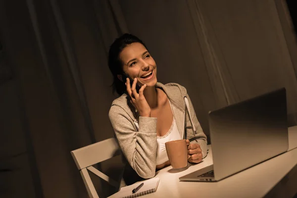 Lachende vrouw praten over smartphone thuis — Gratis stockfoto