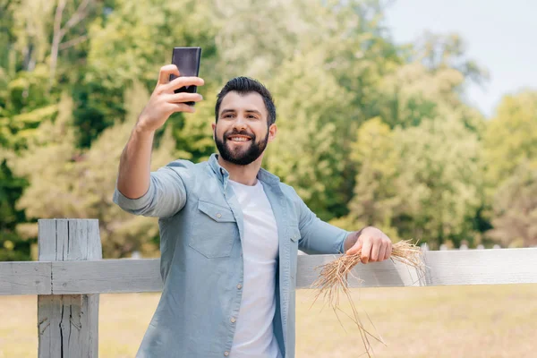 Мужчина делает селфи на смартфоне — стоковое фото