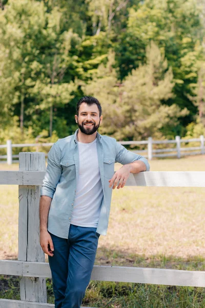 Man standing at wooden fence — Stock Photo, Image