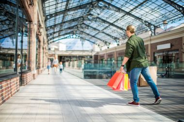 alışveriş torbaları alışveriş merkezinde yürüyen adam