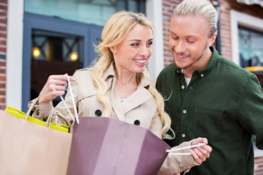 couple looking into shopping bags clipart