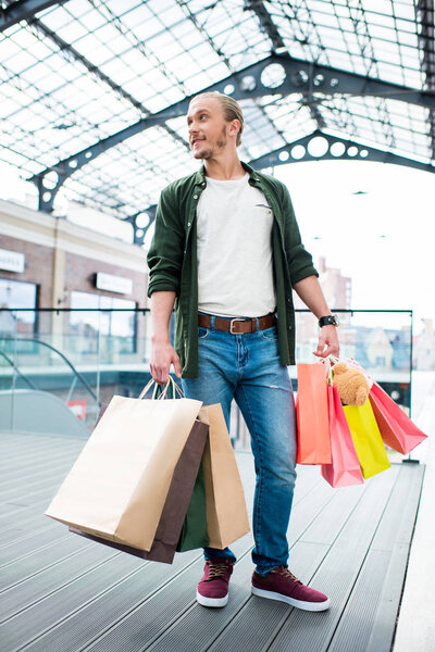 man with shopping bags in mall