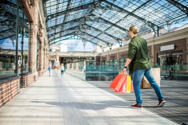 Man vandrar shoppingkassar i mall — Stockfoto