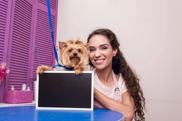 Groomer and dog with blank board — Stock Photo, Image