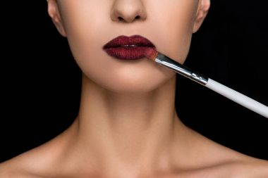 woman applying dark lipstick  clipart