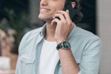 Akıllı telefonu olan genç bir adam.