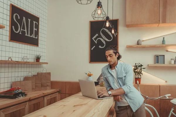 Shop owner using laptop — Stock Photo, Image