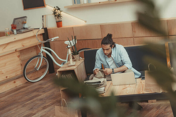 small business owner with clothes and laptop