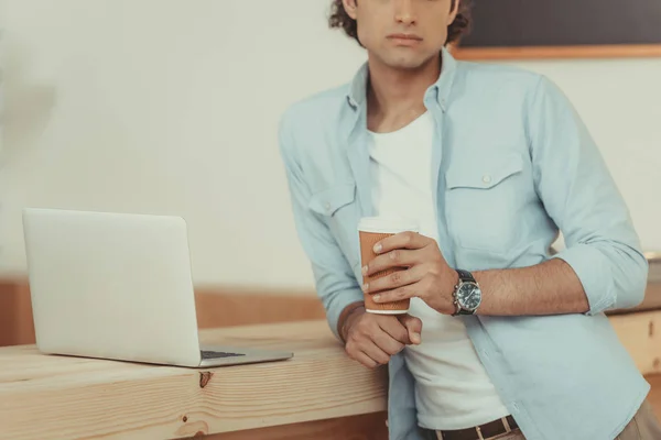 Man using laptop and drinking coffee — Free Stock Photo