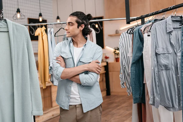 Homem trabalhando com roupas em boutique — Fotografia de Stock