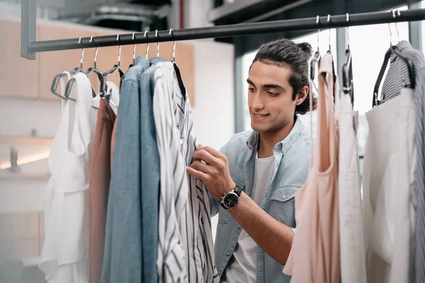 Homme travaillant avec des vêtements en boutique — Photo