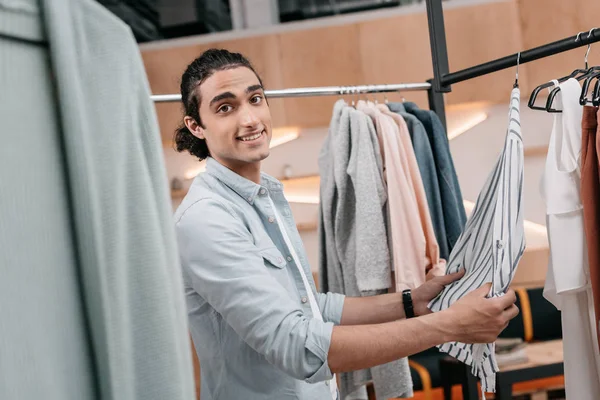 Homme travaillant avec des vêtements en boutique — Photo