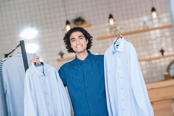 Man choosing shirts in boutique — Free Stock Photo