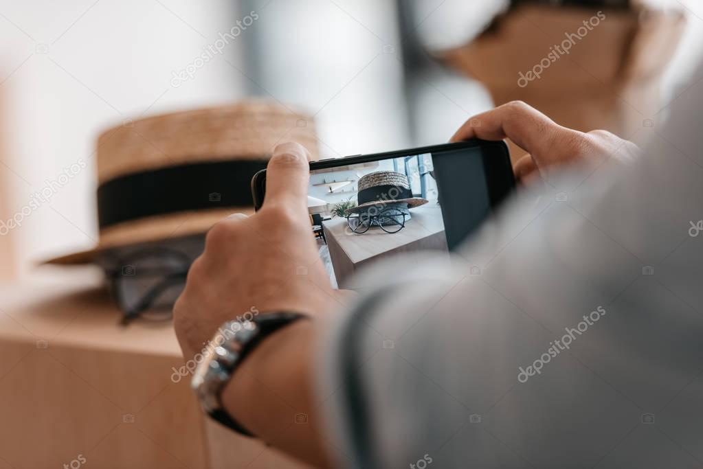 man photographing accessories with smartphone 