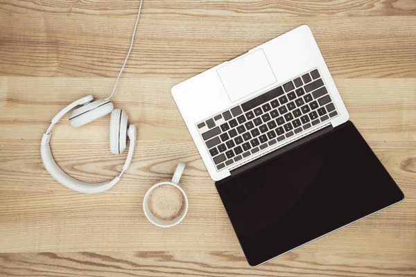 Laptop com tela em branco e fones de ouvido — Fotografia de Stock