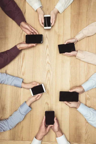 Empresários com smartphones em reunião — Fotografia de Stock
