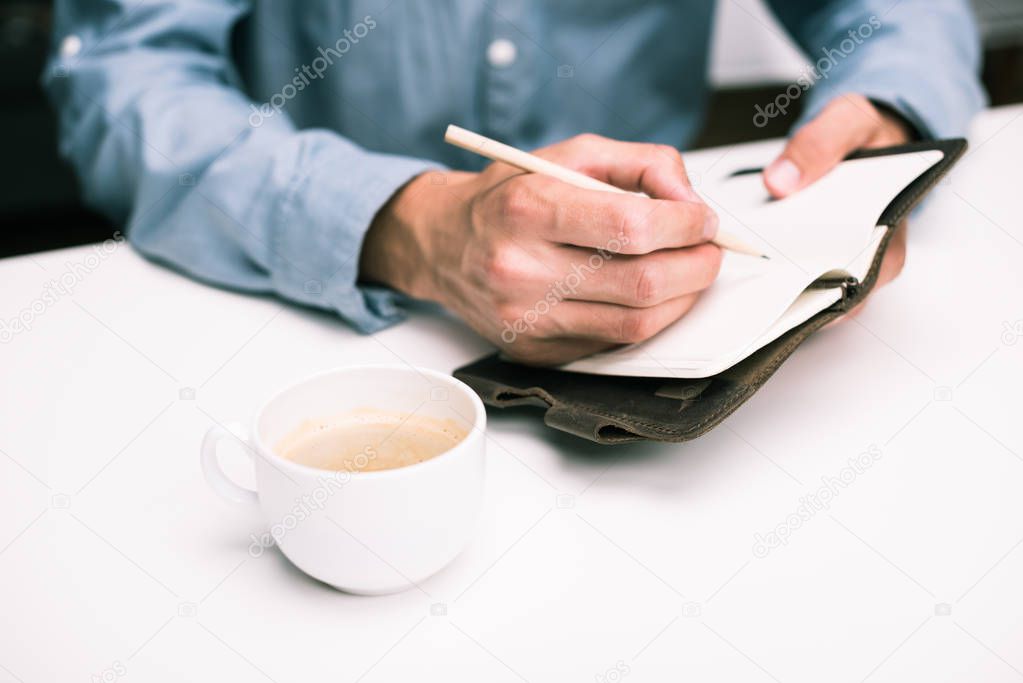 man writing in diary