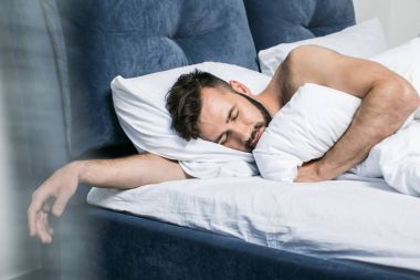 handsome young man sleeping in bed clipart
