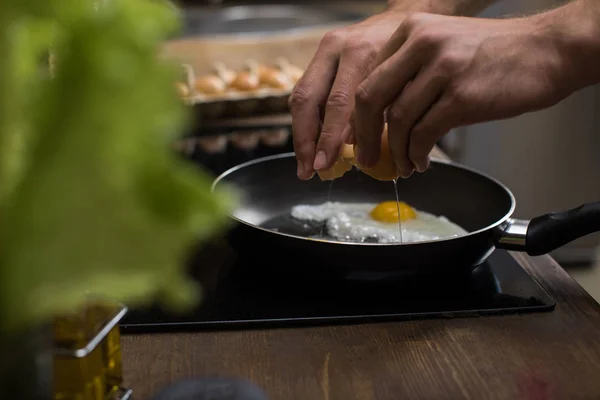 Young man preparing eggs — Stock Photo, Image