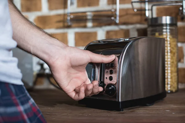 Man turning on toaster — Stock Photo, Image