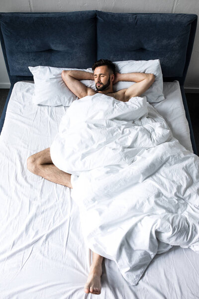 handsome young man sleeping in bed