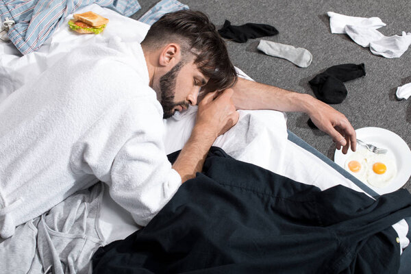 tired young man in bathrobe sleeping