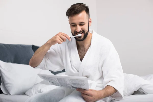 Hombre en albornoz cepillarse los dientes —  Fotos de Stock