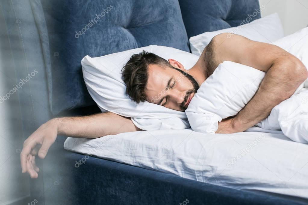 Handsome young man sleeping in bed — Stock Photo Handsome young man sleeping in bed — Stock Photo