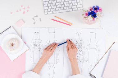 Taslaklarla çalışan moda tasarımcısı