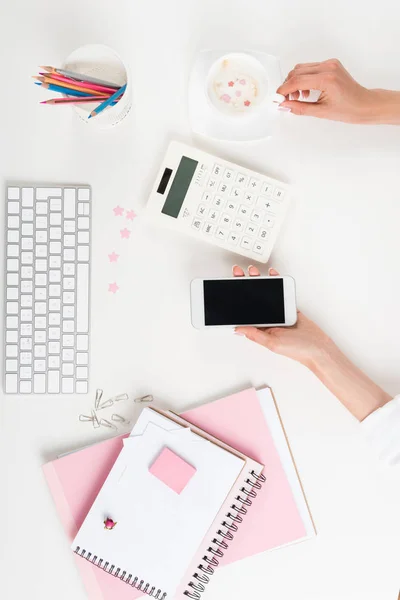 Mains féminines avec smartphone et cappuccino — Photo