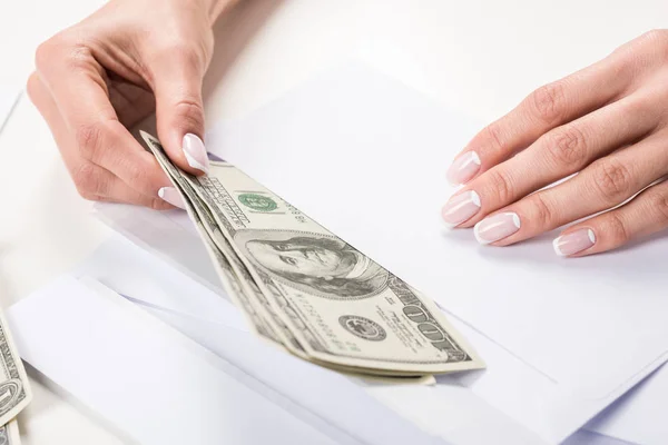Kobiecych rąk z banknotów dolara w kopercie — Zdjęcie stockowe