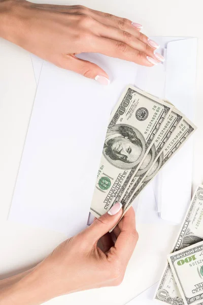 Жіночі руки з доларовими банкнотами в конверті — стокове фото