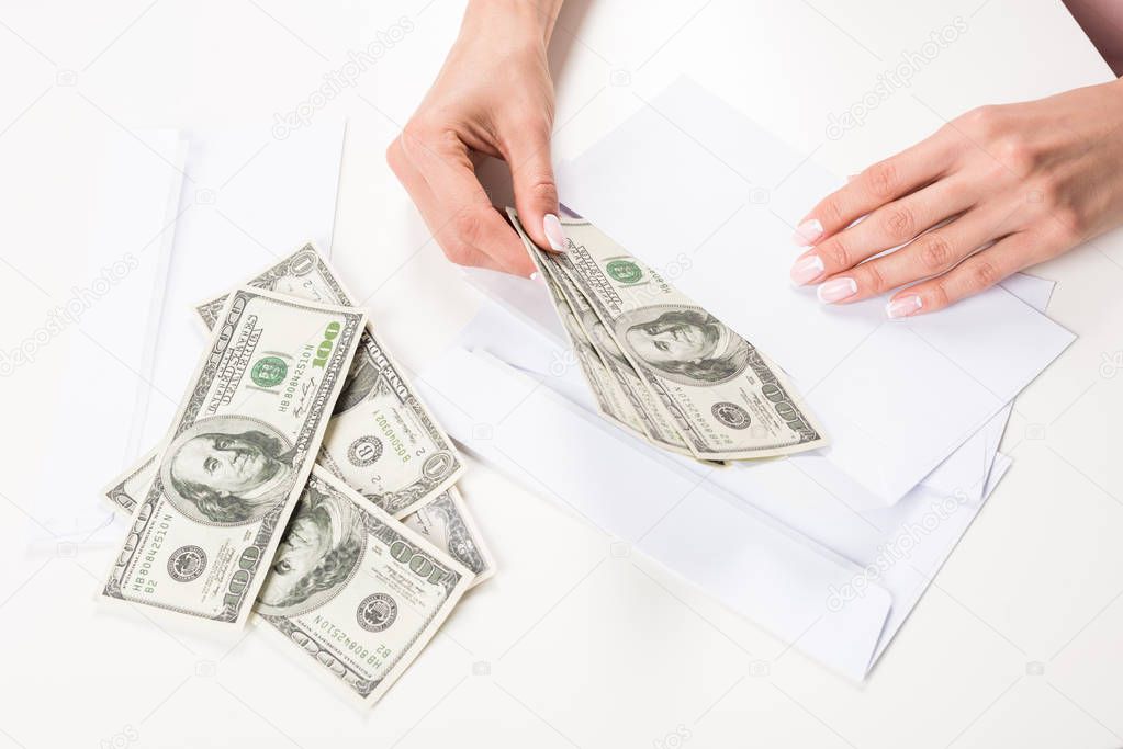 female hands with dollar banknotes in envelope   