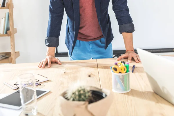 Geschäftsmann stützt sich auf Arbeitsplatz — Stockfoto