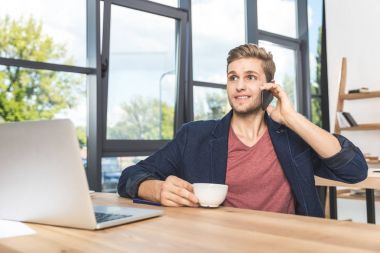 İşyerinde smartphone cep telefonu ile konuşurken işadamı