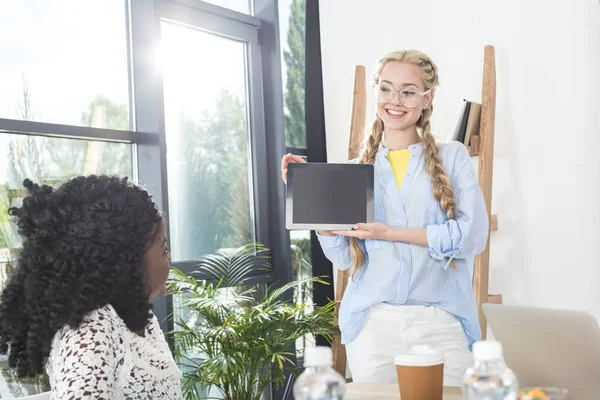 Businesswoman showing tablet to colleague — Free Stock Photo