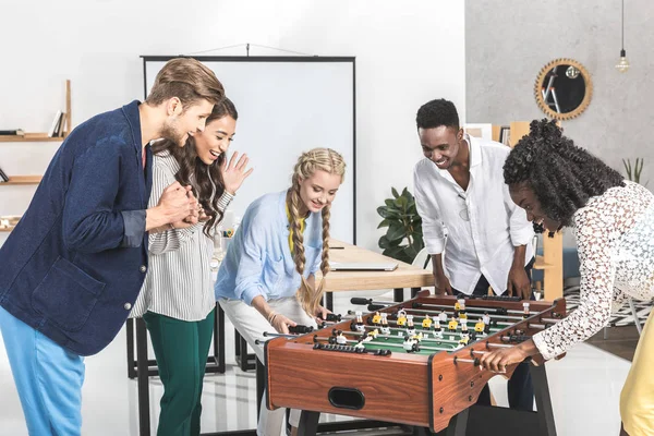 Multikulturelle Kollegen spielen Tischfußball — Stockfoto