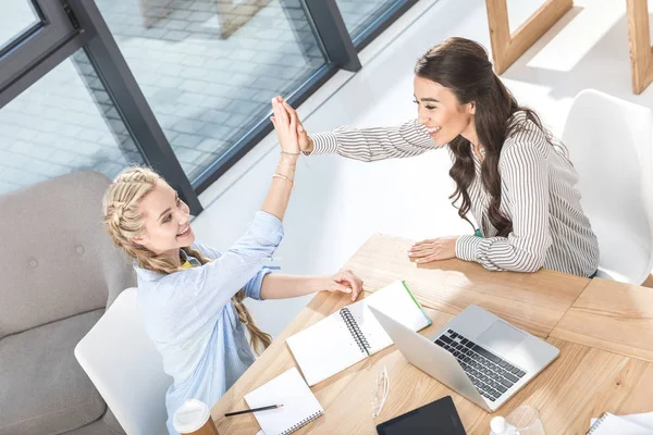 Mujeres de negocios multiculturales dando cinco altos — Foto de Stock