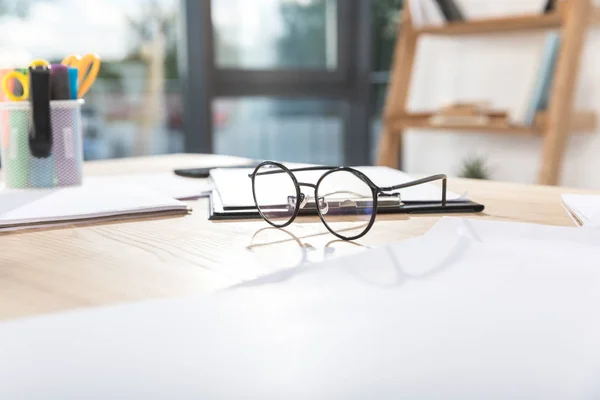 Gafas en el lugar de trabajo con papeles — Foto de Stock