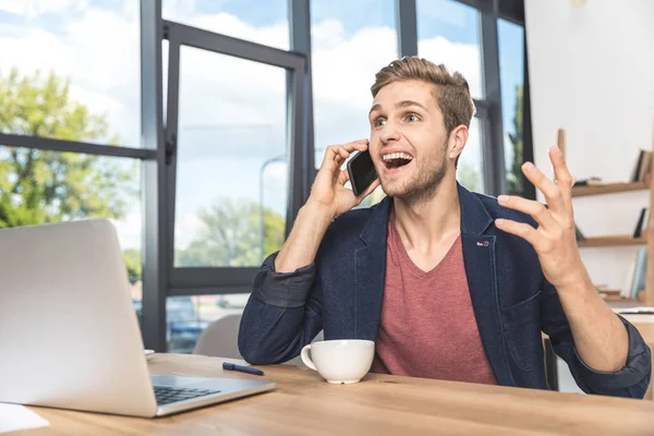 Hombre de negocios hablando en smartphone en el lugar de trabajo —  Fotos de Stock