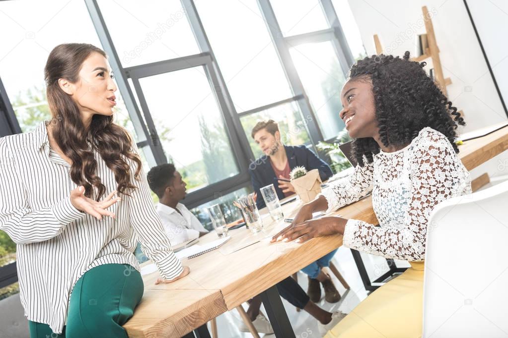 multiethnic businesswomen having conversation in office