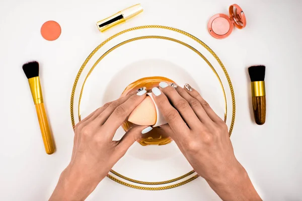 Manos femeninas con esponja de maquillaje — Foto de Stock