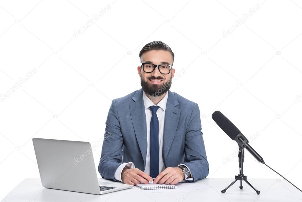 newscaster with laptop and microphone