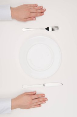 eller, boş tabak ve çatal bıçak takımı