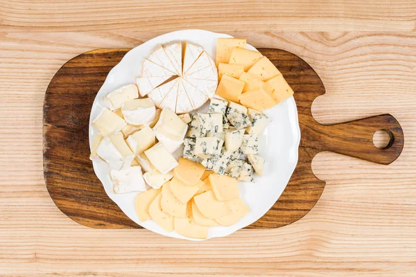 Variety of cheese kinds on wooden board — Stock Photo, Image