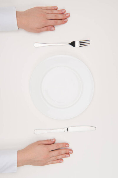 hands, empty plate and cutlery