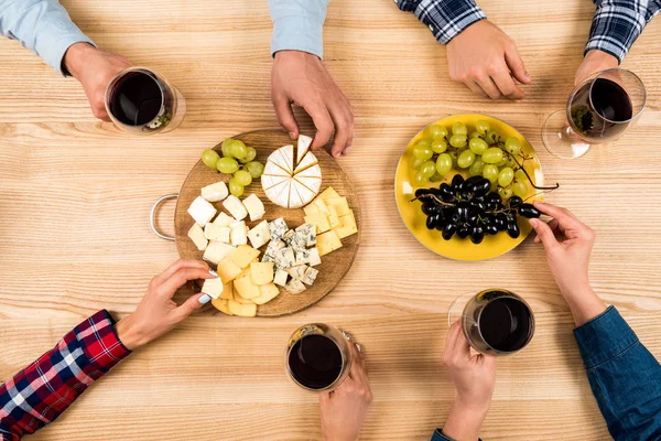 Amici che mangiano formaggio e bevono vino — Foto Stock