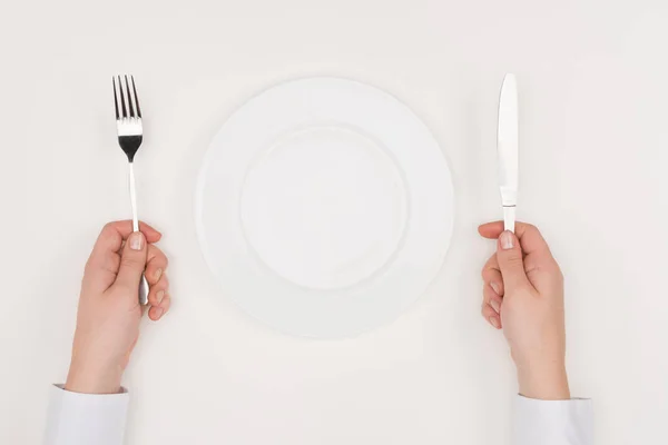 Hands, empty plate and cutlery — Stock Photo, Image