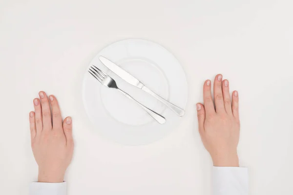 Hands, empty plate and cutlery — Stock Photo, Image